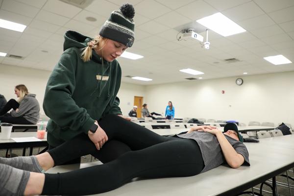 Student performing physical therapy on someone else
